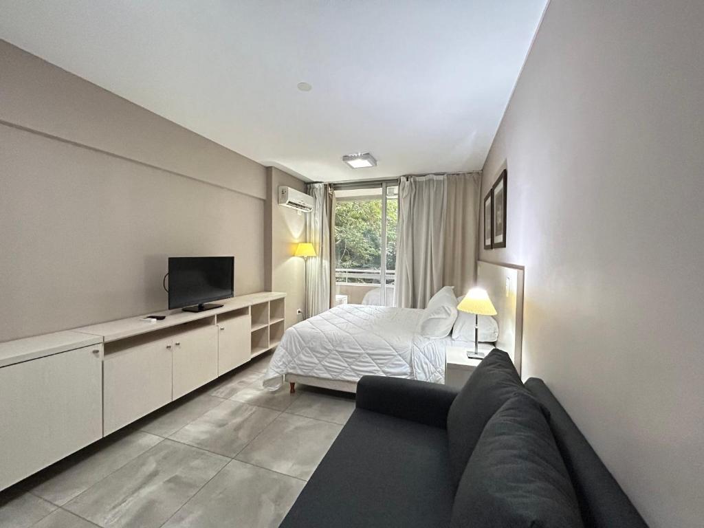 a bedroom with a bed and a couch and a television at Marais Recoleta in Buenos Aires
