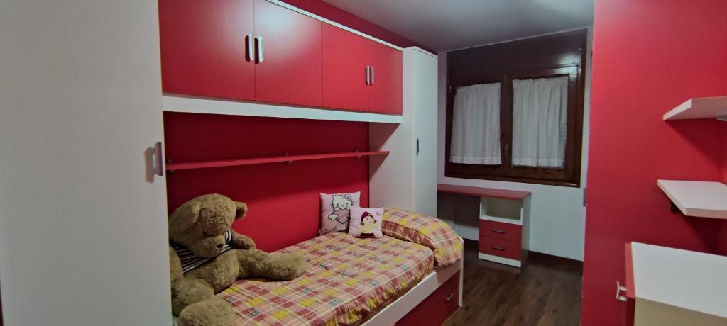 un pequeño dormitorio con un osito de peluche sentado en una cama en Alojamiento Tierra del Ara, en Boltaña