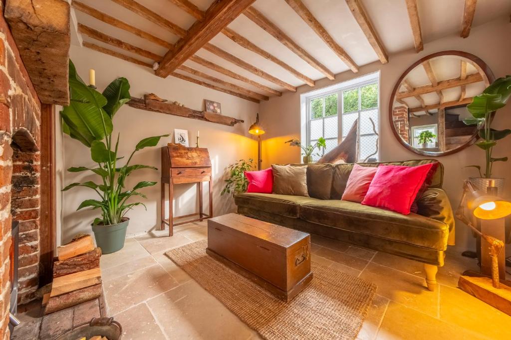 a living room with a couch and a mirror at Most romantic cottage in Suffolk - Number Four in Framlingham