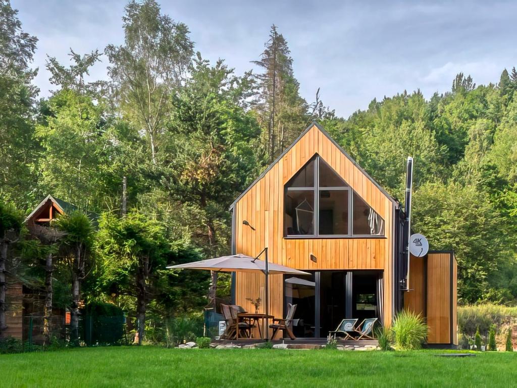 una pequeña casa de madera en un campo de hierba en Babia Ostoja - domek z balią i sauną, en Zawoja