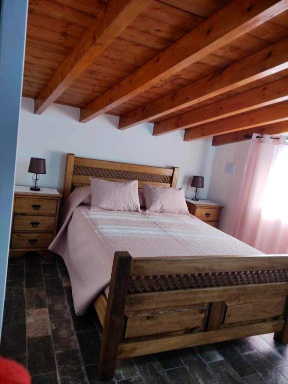 1 dormitorio con 1 cama grande de madera y 2 mesitas de noche en Charming House in Redondo + Air Conditioned, en Redondo
