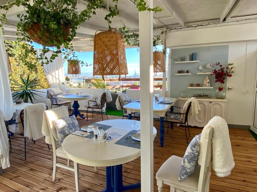 un restaurante con mesas y sillas y una gran ventana en Casa Doramas B&B VV en Las Palmas de Gran Canaria