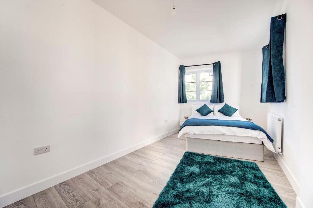a white bedroom with a bed and a green rug at 2 bedroom apartment with large rooms and Wi-Fi in London