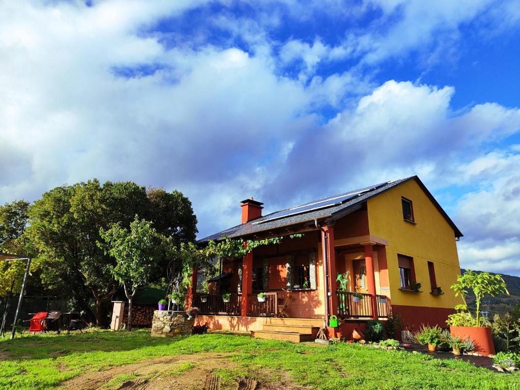 una casa en una colina de hierba con un cielo en A Porteliña Casa Rural en Ambas Aguas