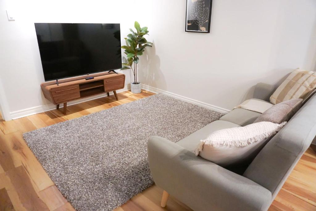 sala de estar con sofá y TV de pantalla plana en Cozy apartment in Ahuntsic with Free Parking and near metro station en Montreal