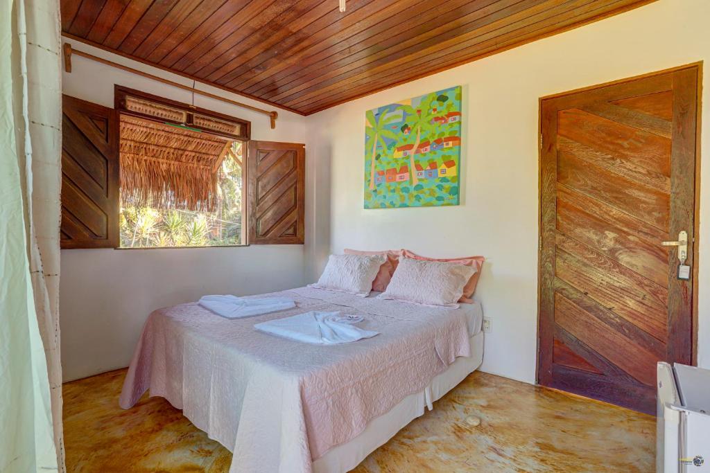 um quarto com uma cama e um tecto de madeira em Pousada casa zaza em Itacaré