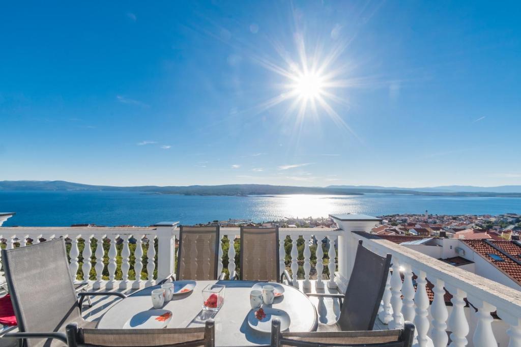 einen Balkon mit einem Tisch und Stühlen sowie Blick auf das Wasser in der Unterkunft Apartment in Crikvenica with sea view, terrace, air conditioning, WiFi 3492-8 in Crikvenica