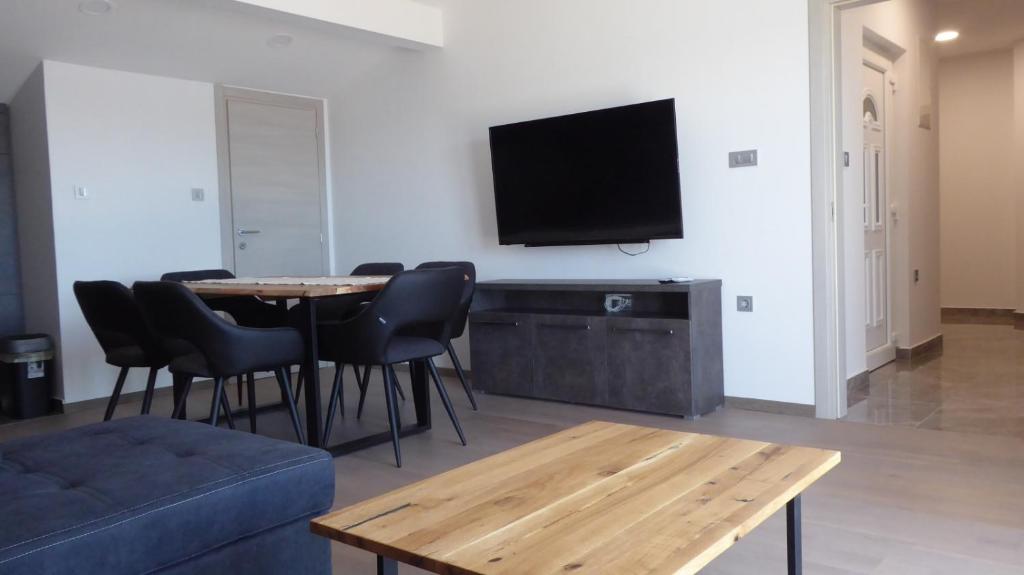 a living room with a table and a tv on a wall at Apartment in Crikvenica with sea view, balcony, air conditioning, WiFi 4973-1 in Crikvenica