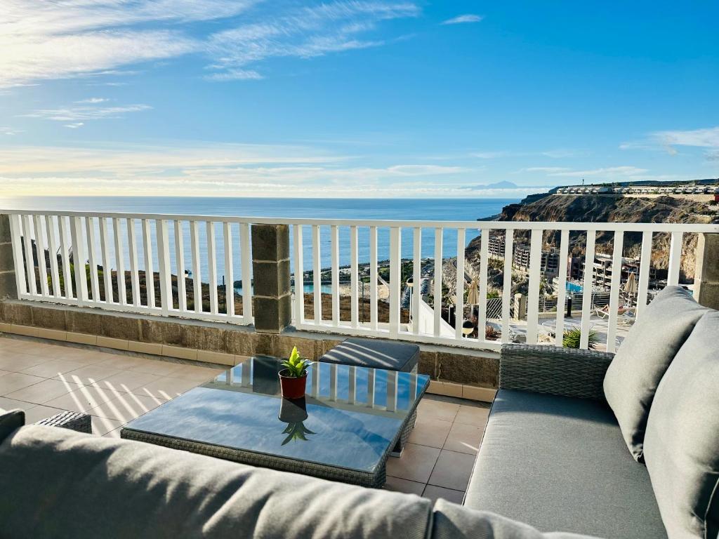 einen Balkon mit einem Sofa und Meerblick in der Unterkunft AMADORES BEACH VIEW APARTMENT in Amadores