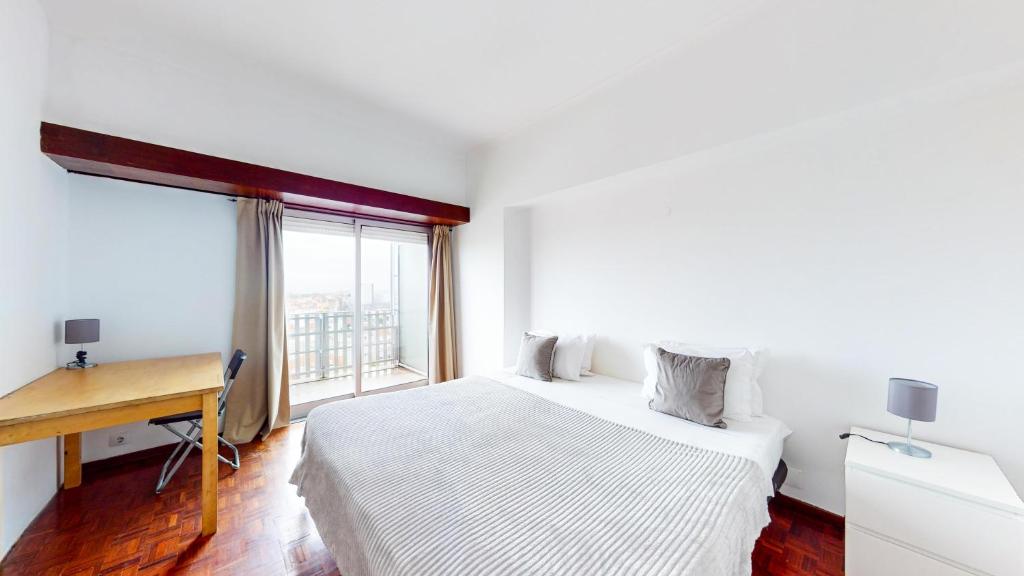 - une chambre avec un lit, un bureau et une fenêtre dans l'établissement Panoramic View Saldanha, à Lisbonne