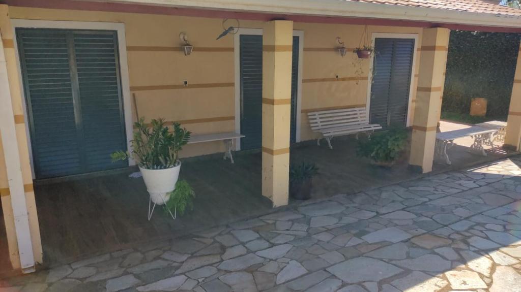 een veranda van een huis met een bank en luiken bij Casa de Campo Acolhedora e Confortável in Ribeirão Preto