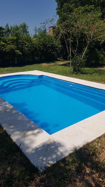 a large blue swimming pool in a yard at Cabaña Don Suso in Paso de la Patria
