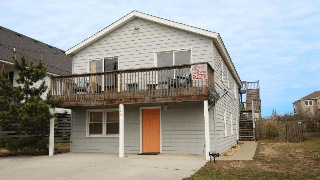a white house with a balcony with a deck at Oceanside, 5 BRs, Hot Tub, Rec Room, Close to Shopping, KH221, Shoebies Hangout in Kitty Hawk