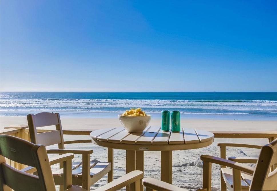 a table and chairs on a beach with the ocean at Salt Life in San Diego