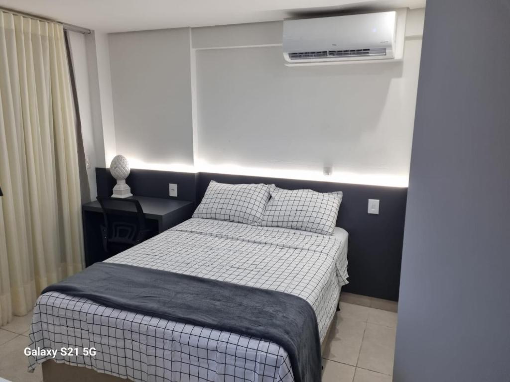 a bedroom with a bed and a air conditioner at Flat Luxo Jardim Goiás in Goiânia