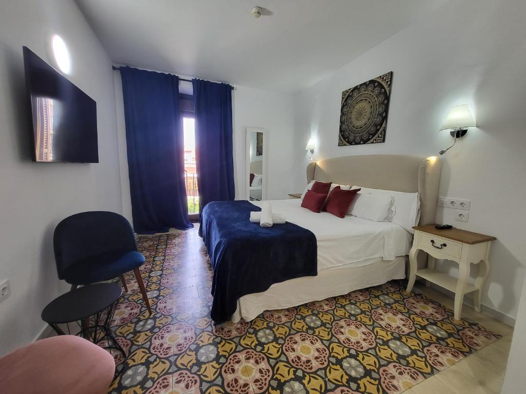 セビリアにあるCasona de San Andrésのベッドと椅子付きのホテルルーム