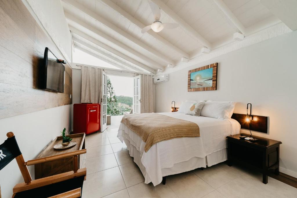 a bedroom with a large bed and a large window at Baía do João Eco Pousada in Búzios