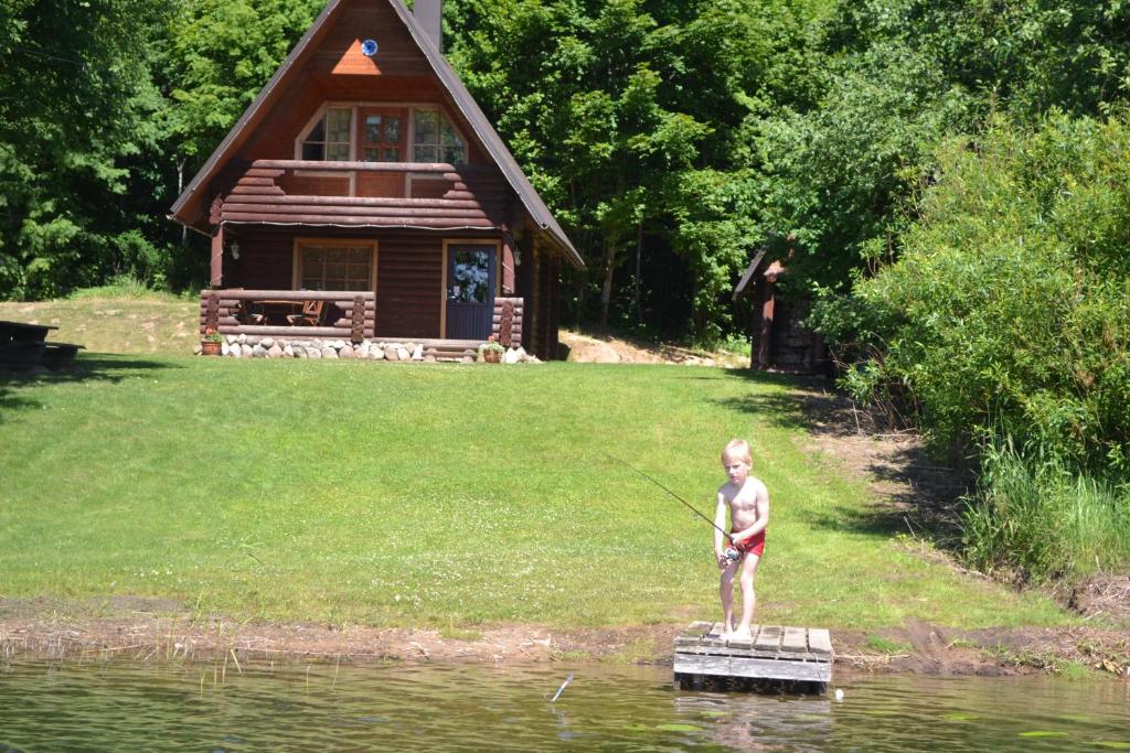 Un jeune garçon debout sur un radeau dans l&#39;eau dans l&#39;établissement Lõõdla Holiday House, à Lümatu