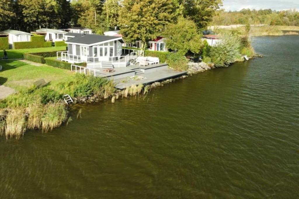 a large house on the side of a river at Chalet "Aan ut water" Elburg in Biddinghuizen