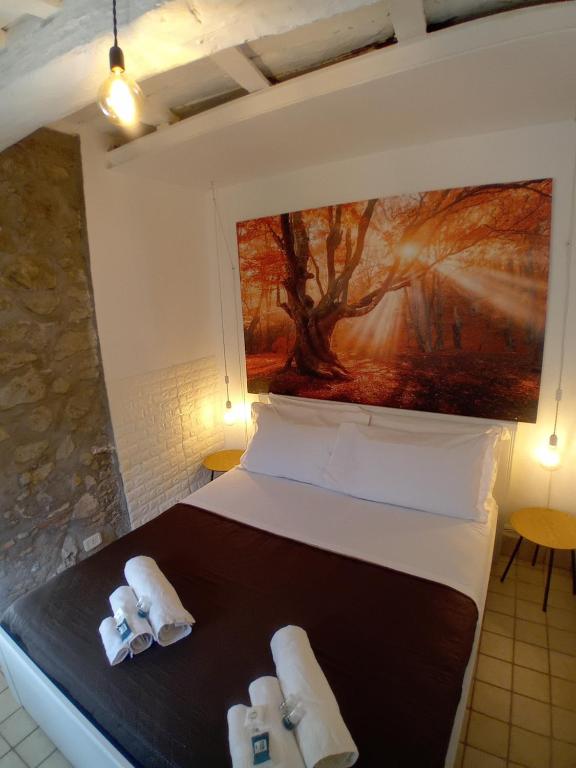 a bedroom with a bed with towels and a painting at Casetta nel Borgo in Olevano Romano
