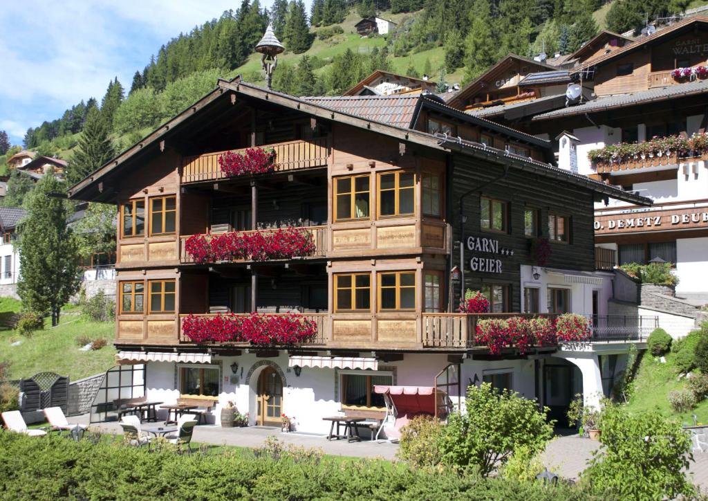 un edificio con flores delante en Garni Hotel Geier, en Santa Cristina Valgardena