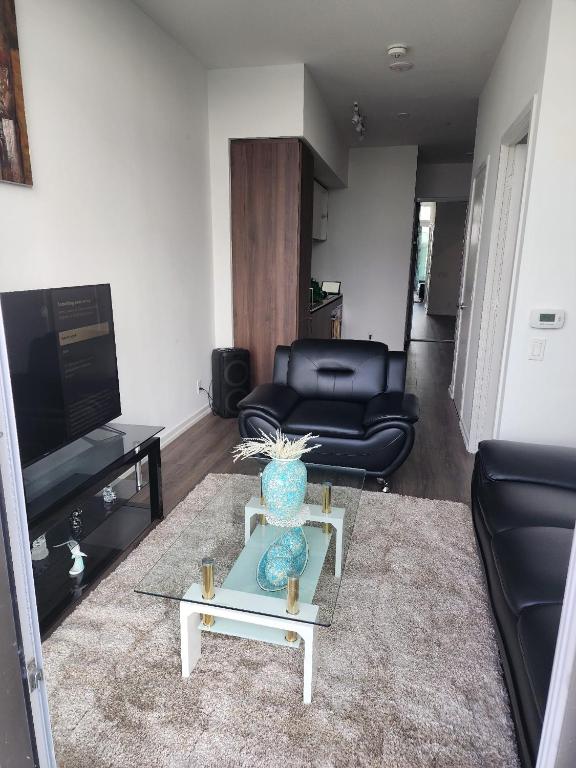 a living room with a couch and a vase on a table at Aethestic Apartment 2bedroom unit in Vaughan