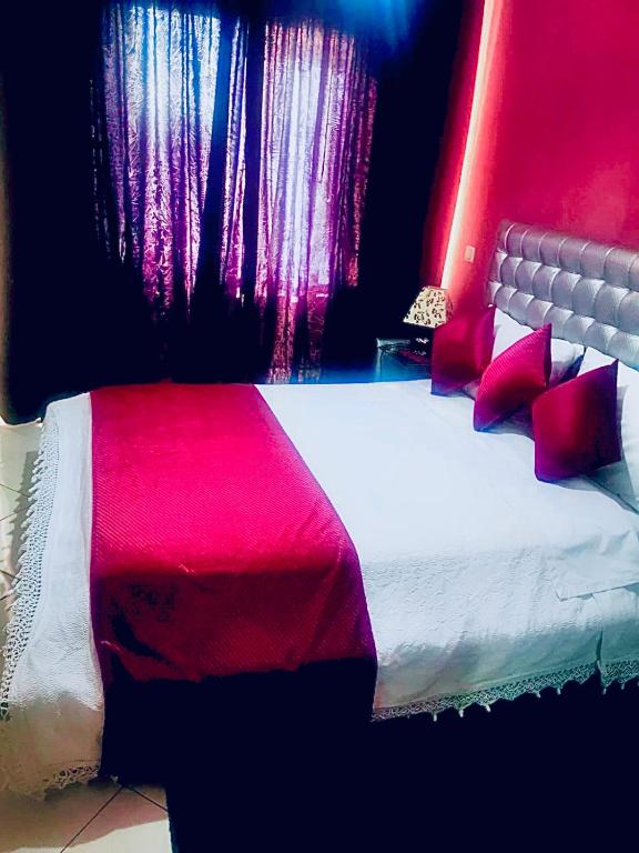 Appartement luxueux Centre Agadir في أغادير: غرفة نوم بسرير وبطانية حمراء وبيضاء
