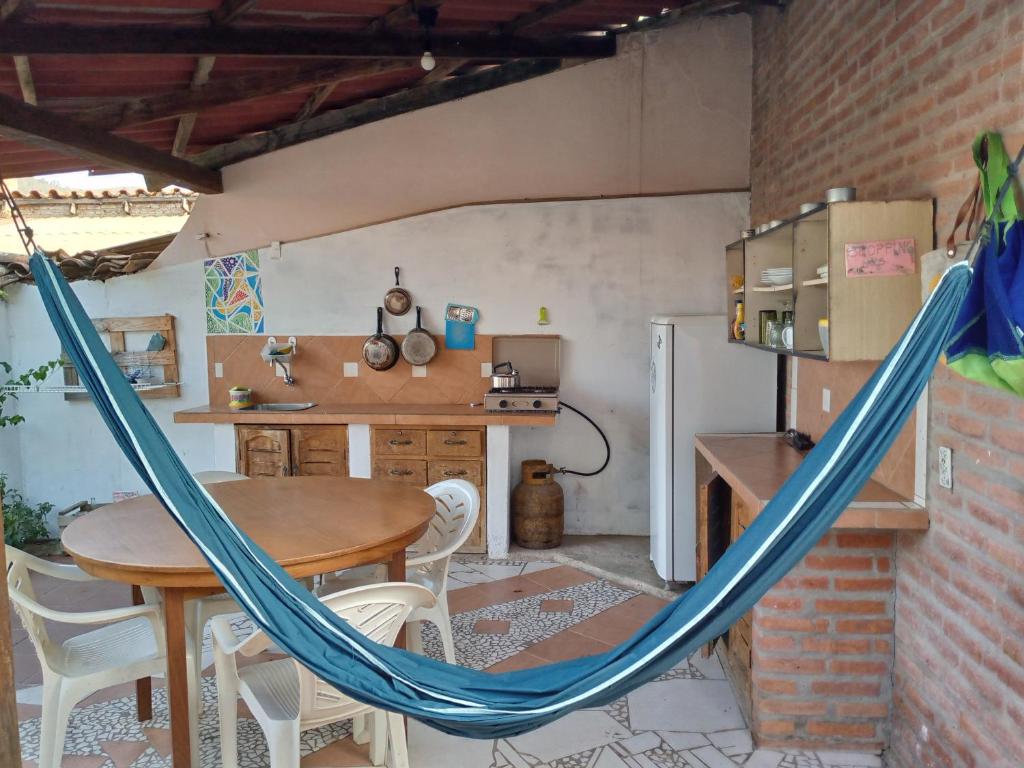 a hammock in a room with a table and a kitchen at Casa Sayana in Samaipata