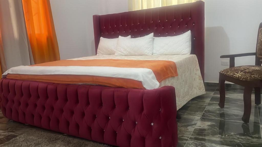 a bed with a red headboard in a room at City suite Apartment 1 Cabrera in Cabrera