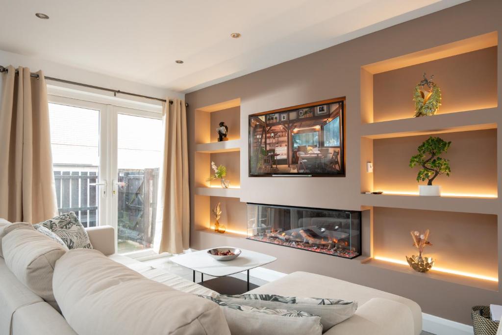 een woonkamer met een witte bank en een open haard bij Cosy Modern City Centre 2 Bed Apartment in Belfast