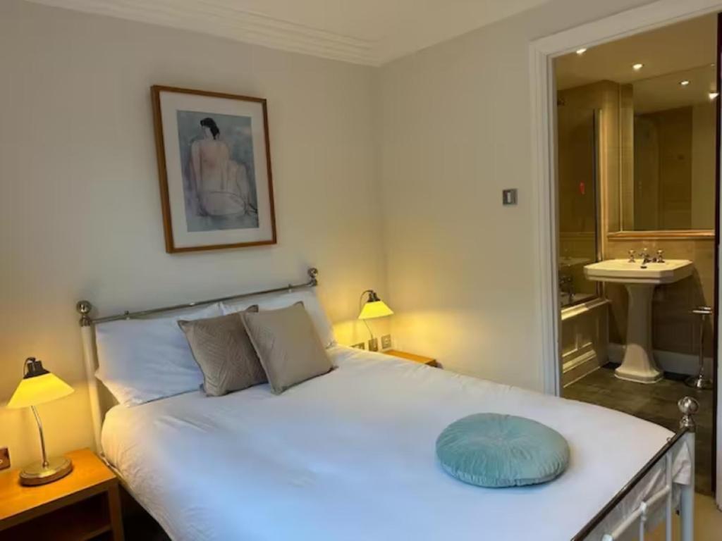 a bedroom with a large white bed and a bathroom at Turner House in London