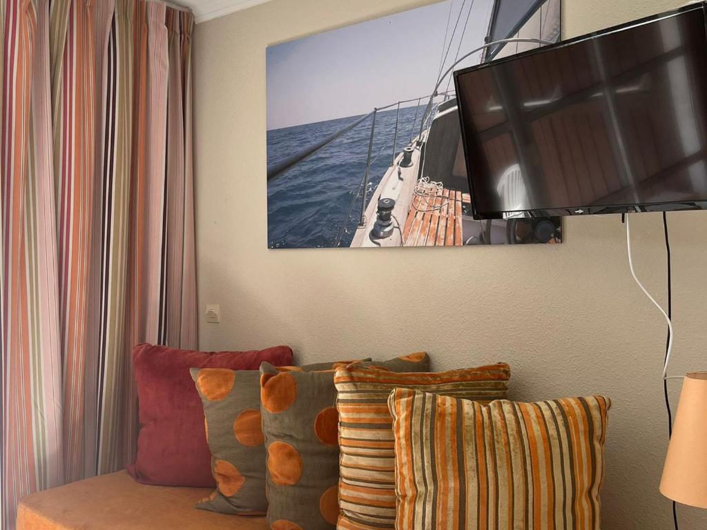 un salon avec une télévision et un canapé dans l'établissement Confort 2 pièces avec terrasse, piscine et parking - FR-1-504-673, à Saint-Raphaël