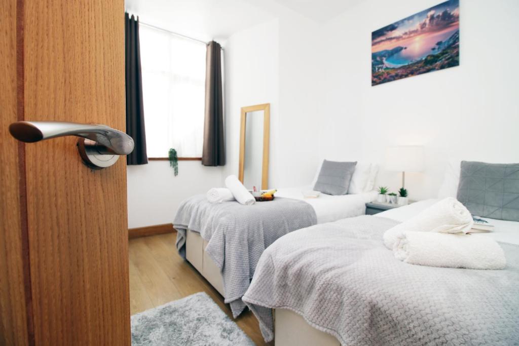 a bedroom with two beds and a window at Perfectly Located City Centre Apartment, Free Parking, Cable TV and WI-FI in Cardiff