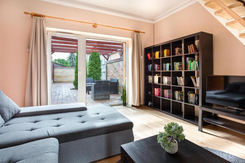 a living room with a couch and a book shelf at Rivercity South Buda Hills in Budapest