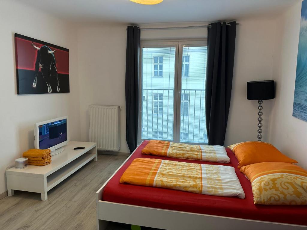 sypialnia z łóżkiem i biurkiem z telewizorem w obiekcie Apartment opera w Wiedniu