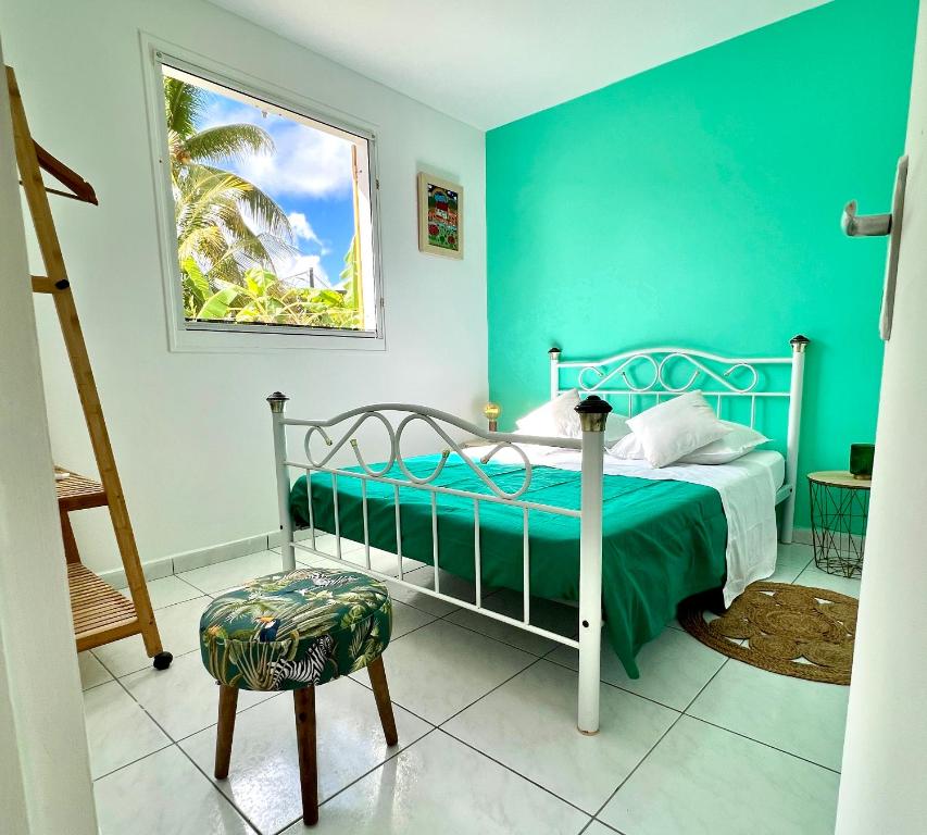 a bedroom with a bed and a green wall at Villa KAZ A ZOT in Port-Louis