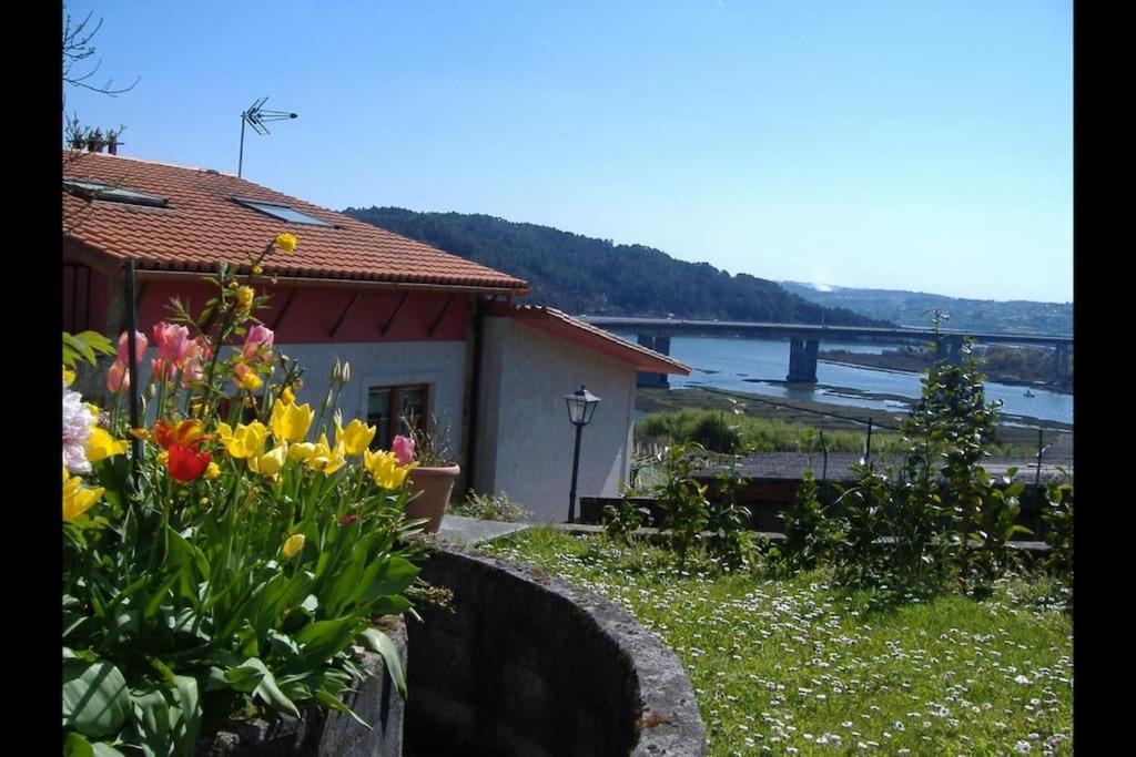 een huis met een boeket bloemen in een tuin bij Chalet en Miño con vistas al mar in Miño