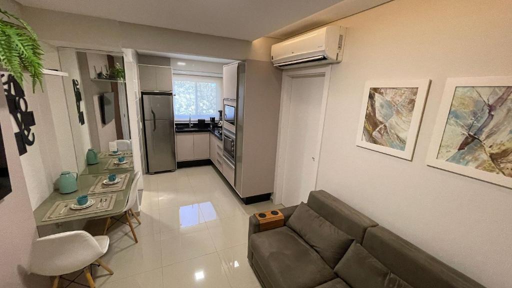 uma sala de estar com um sofá e uma mesa em Lindo e confortável apartamento no Centro de Foz em Foz do Iguaçu