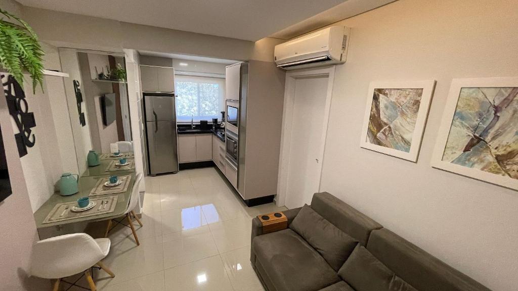 a living room with a couch and a table at Lindo e confortável apartamento no Centro de Foz in Foz do Iguaçu