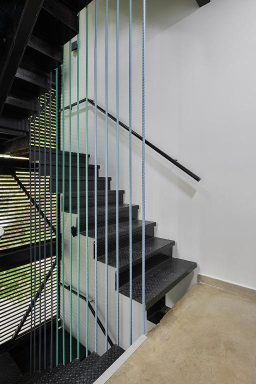 a black staircase with glass railing in a building at Altio Hotel in Cali