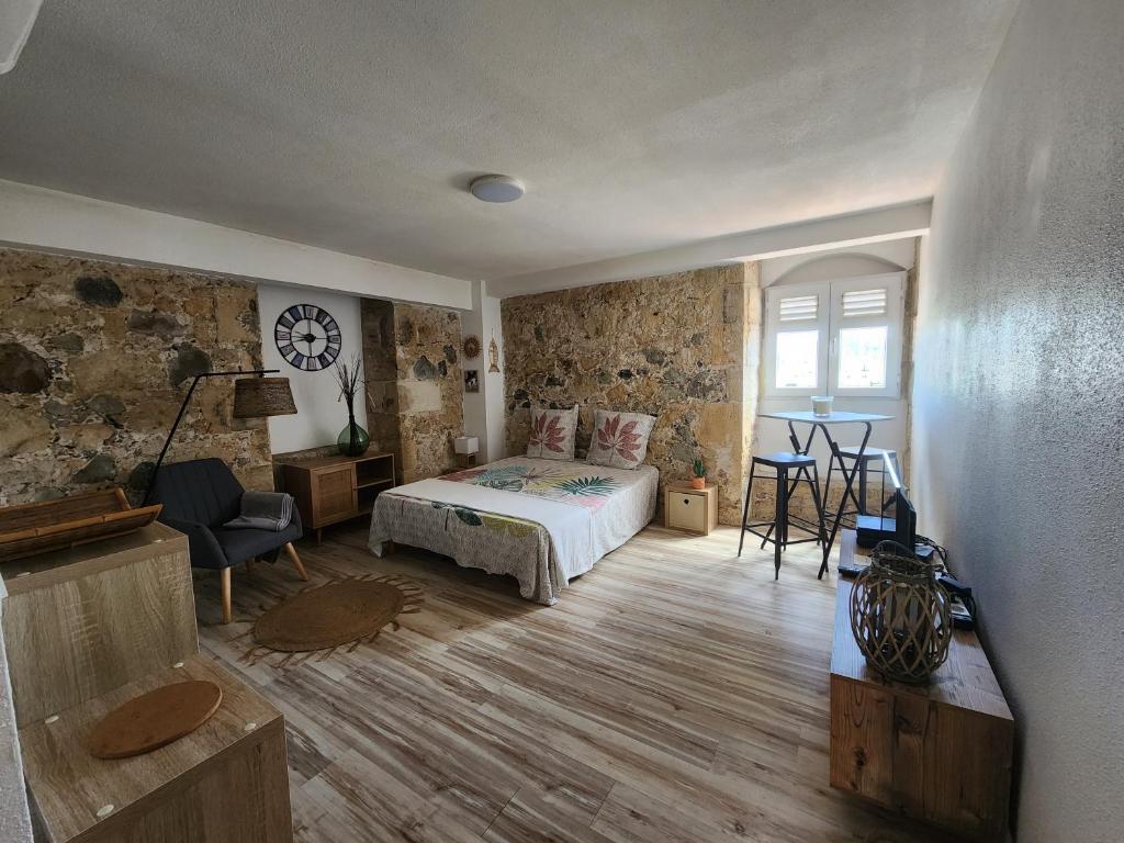 a bedroom with a bed and a table and a chair at Studio face à la Marina, vue mer in Le Marin