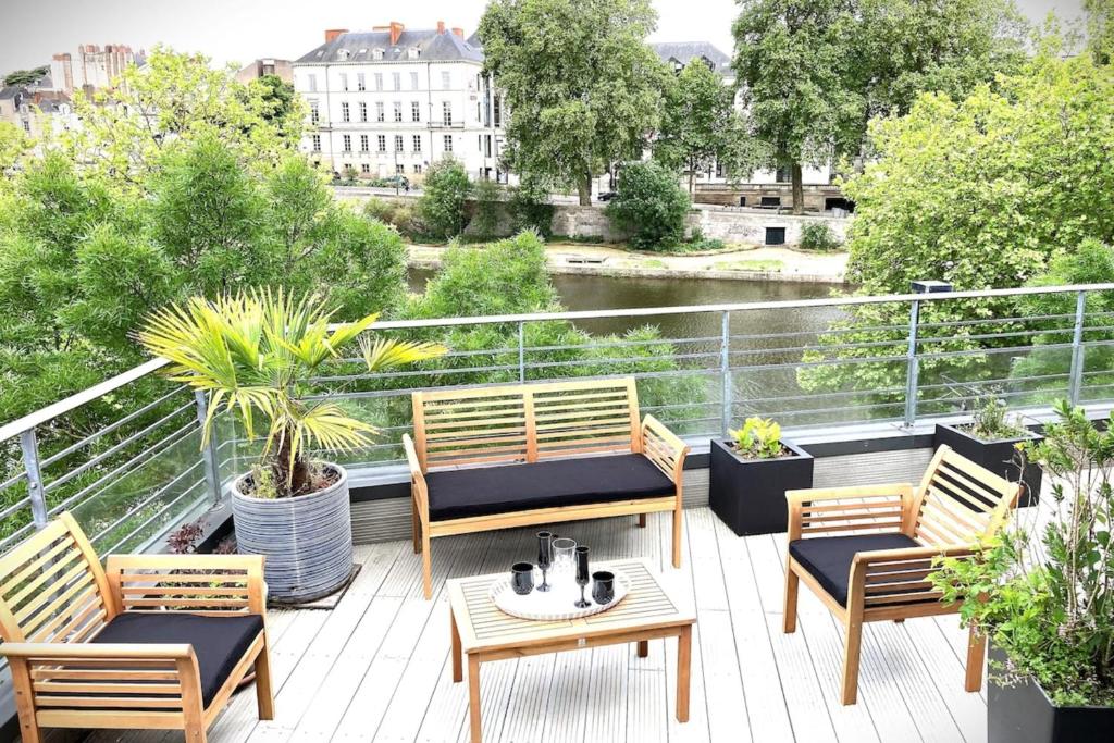 a patio with chairs and tables on a balcony at Le VénitienExceptionnel loft-Rooftop vue Erdre in Nantes