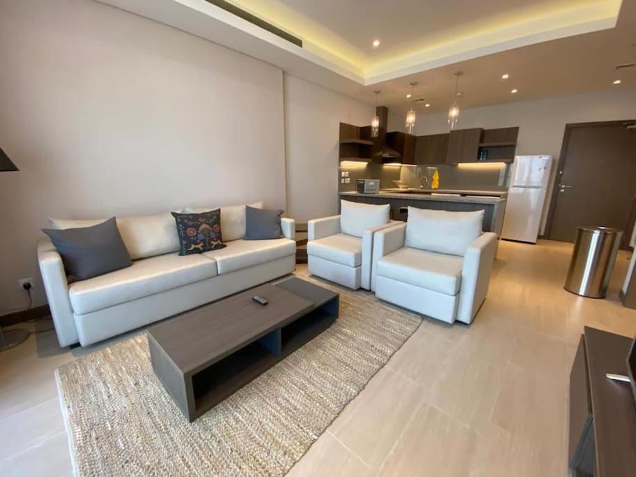 a living room with a couch and chairs and a kitchen at City center area seef Mall in Sanābis