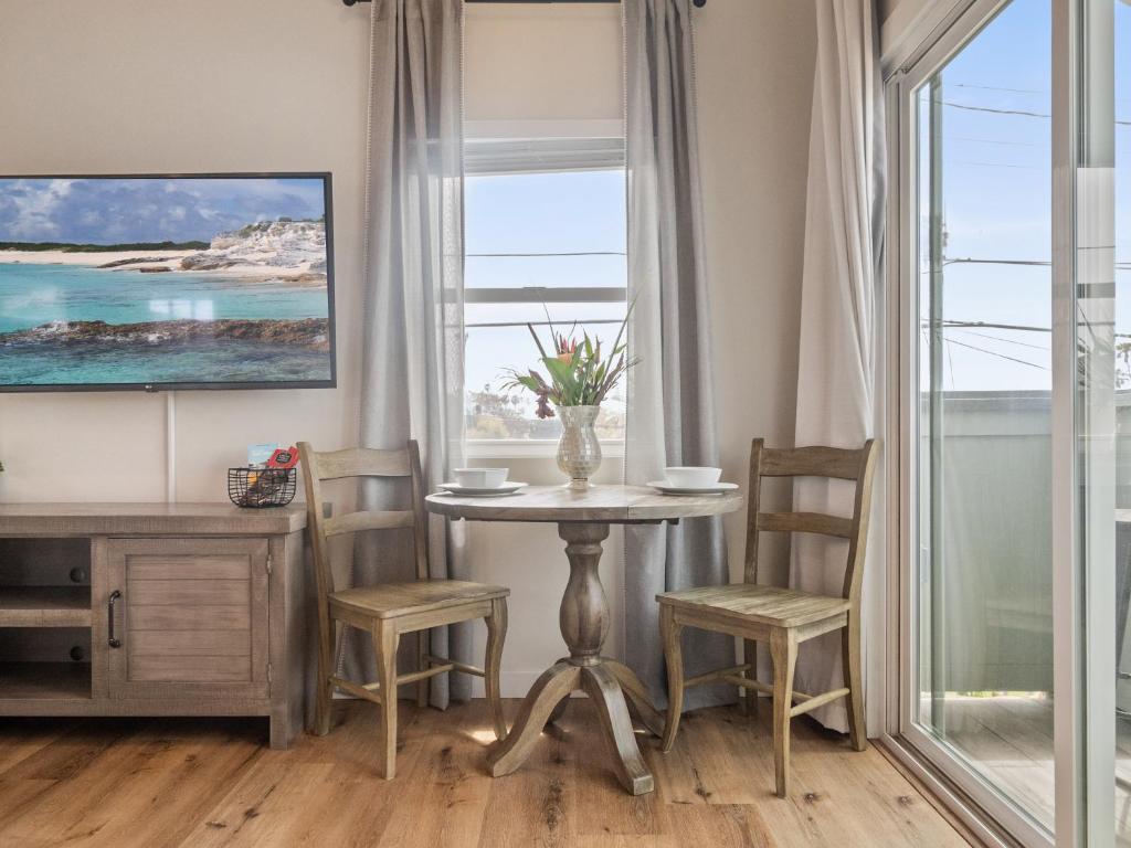 d'une salle à manger avec une table, des chaises et une fenêtre. dans l'établissement A4609b- Sunset Cliffs Dream Apartment, à San Diego