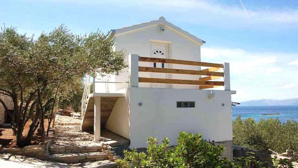 una casa blanca con una valla junto al océano en House Biondina, en Vela Luka
