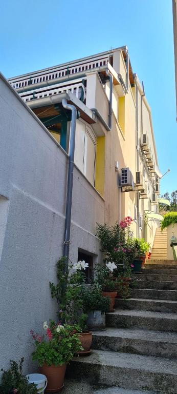 a building with stairs and potted plants in front of it at Apartment Moli Onte Holiday in Milna
