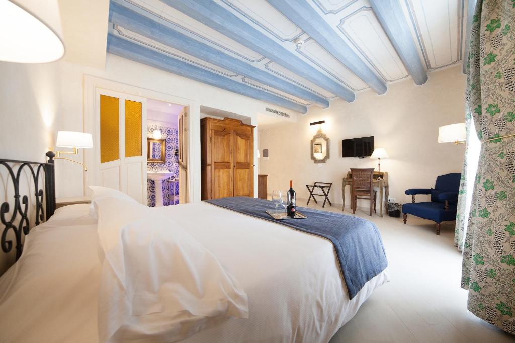 a bedroom with a white bed with a blue ceiling at Algilà Ortigia Charme Hotel in Siracusa