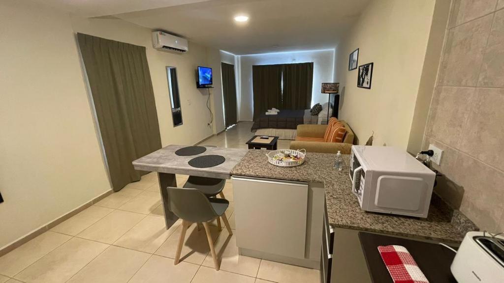 a kitchen with a counter top and a living room at Hermoso departamento en avenida las heras, Resistencia Chaco in Resistencia