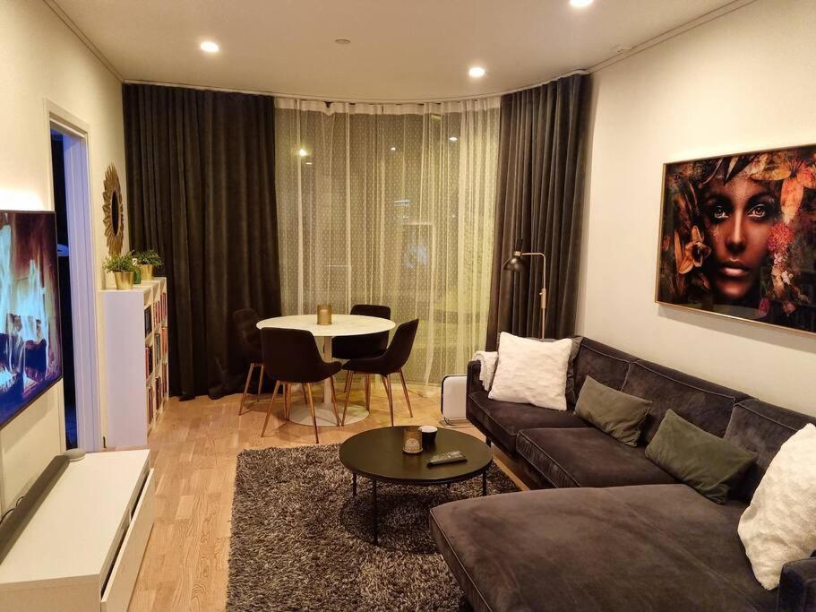 een woonkamer met een bank en een tafel bij NEW modern apartment at Solsiden in Trondheim