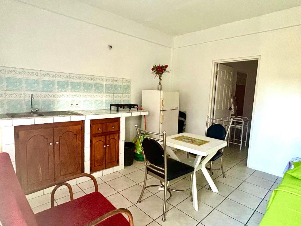 a kitchen with a table and a white refrigerator at Tamernique Apartments in DʼArbeau